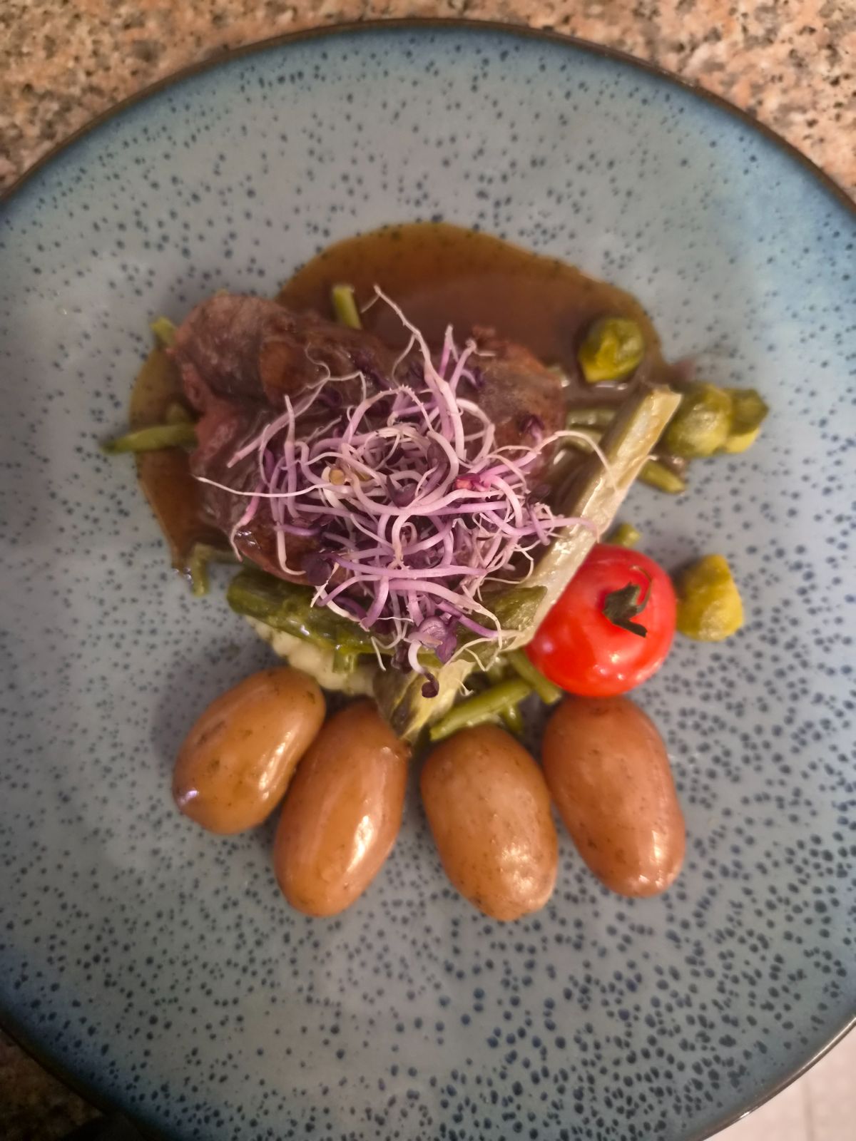 Viande en sauce, pommes de terre et pousses