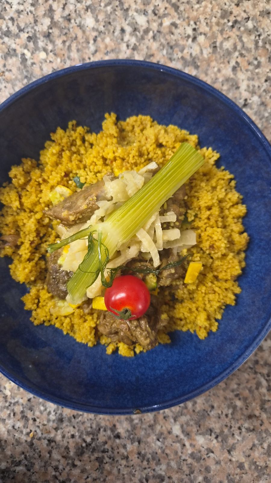 Riz jaune aux légumes dans une assiette bleue